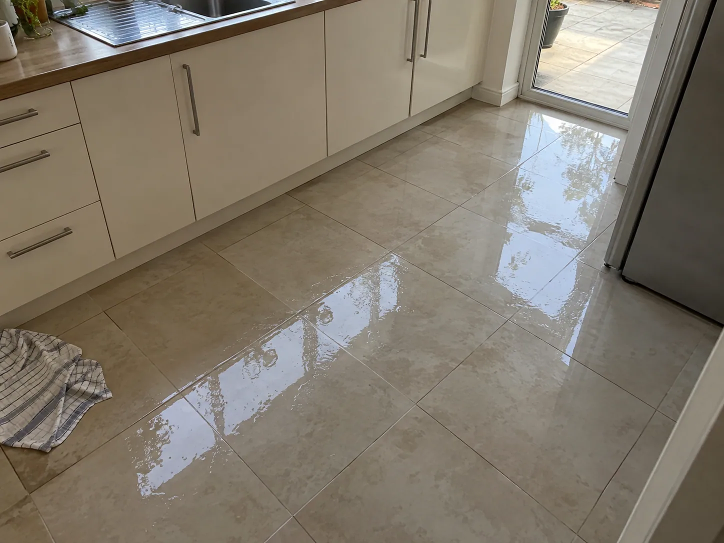 Water spreading across a kitchen floor in a Dallas home